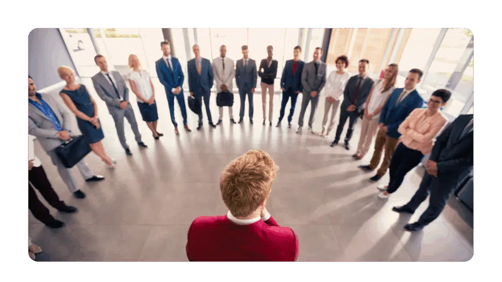 Leader at the center of a circle of employees representing the heart of leadership as an act of service not ego