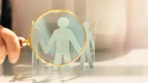 magnifying glass over paper cutouts of people to represent staffing