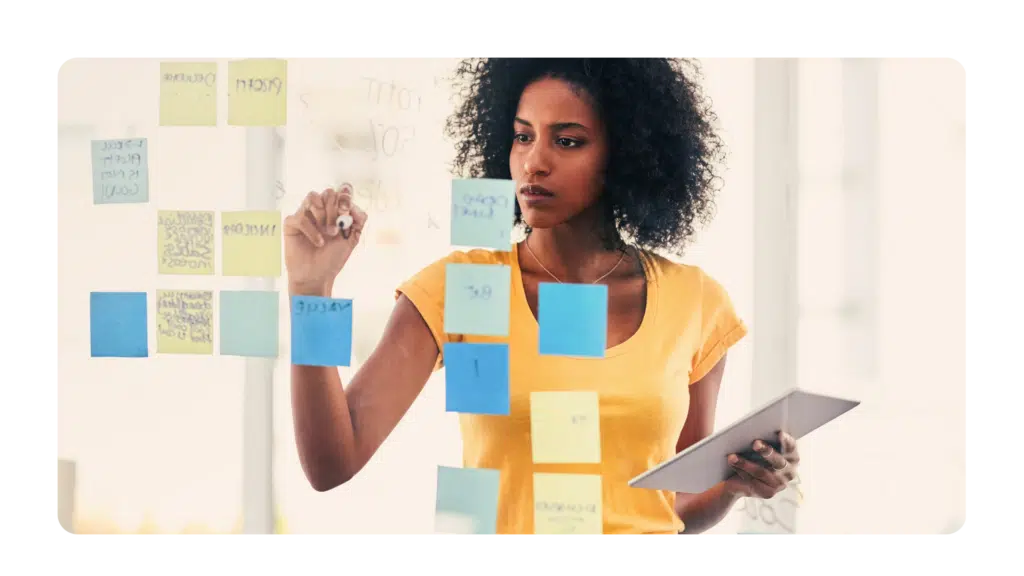 Woman writing goals on post it notes