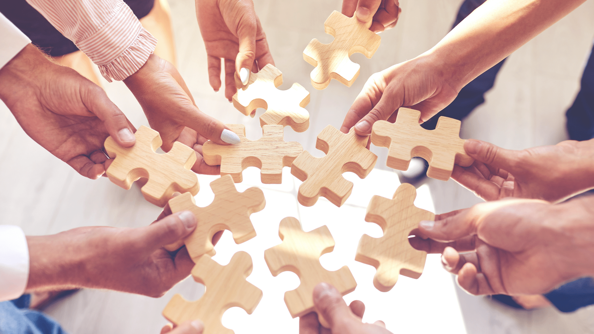 Team holding puzzle pieces representing how a healthy culture supports strategy