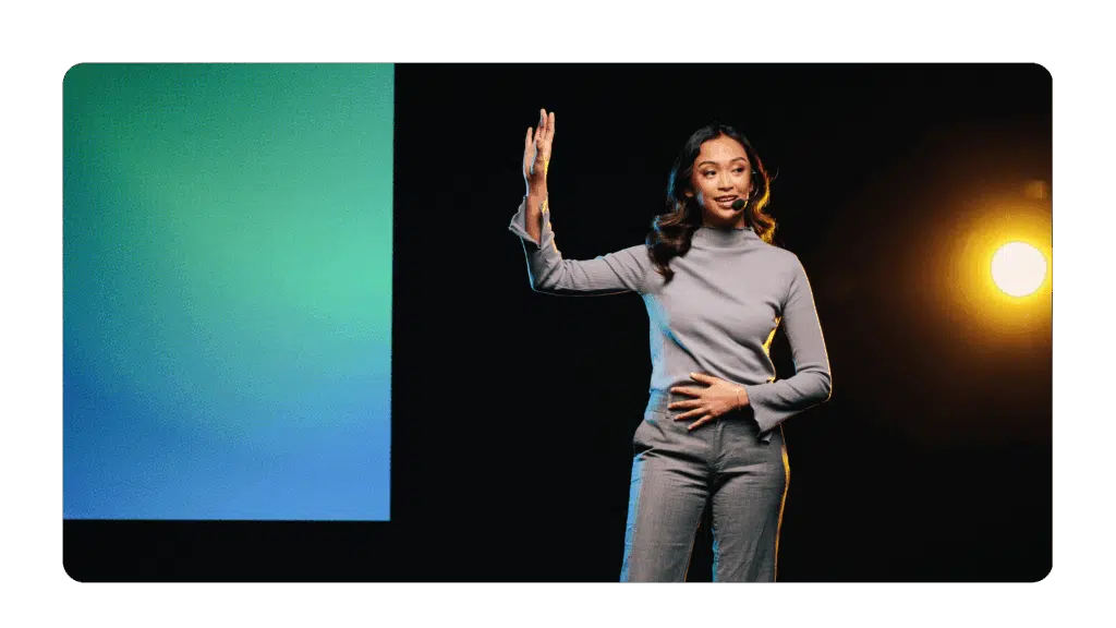 woman on stage using powerful body language to ensure she has a strong executive presence on camera