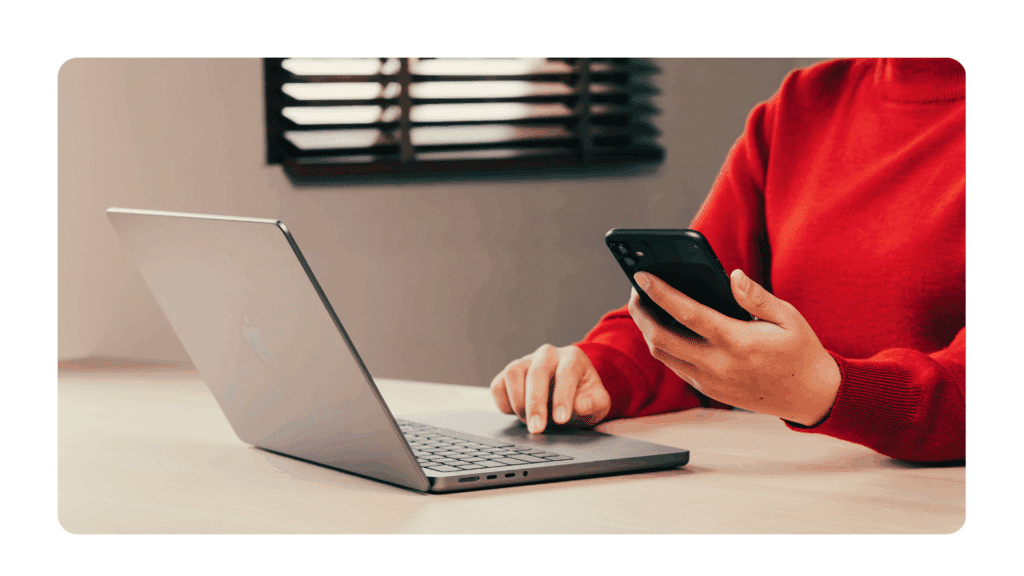picture of woman working on laptop and holding cellphone as she invites participants to a strategic planning offsite