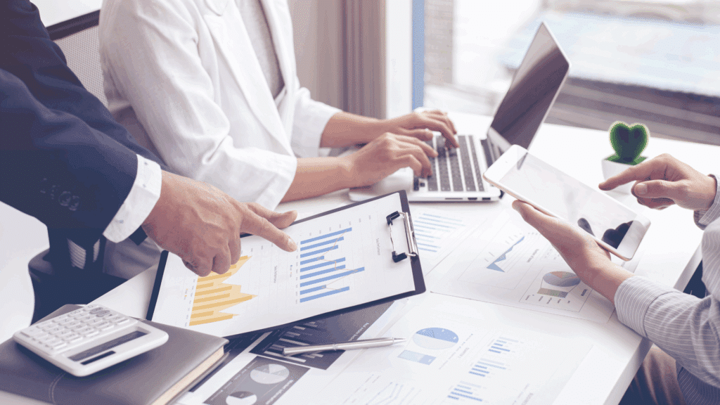 close up of business professionals pointing at graphs and charts representing strategic planning in unpredictable times